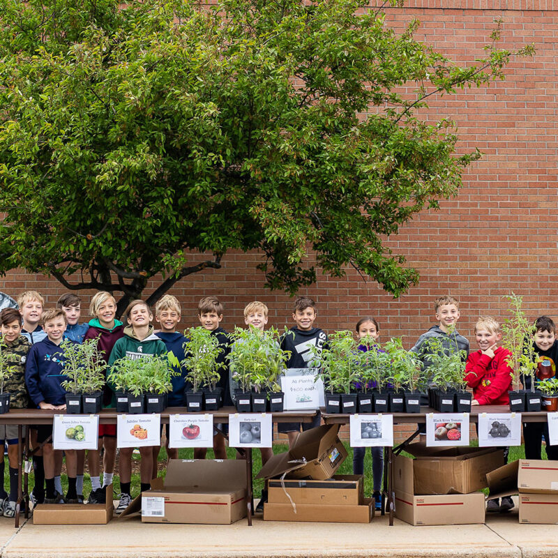 4th grade Rose Park students lined up behind their tomato plants ready to sell them to customers