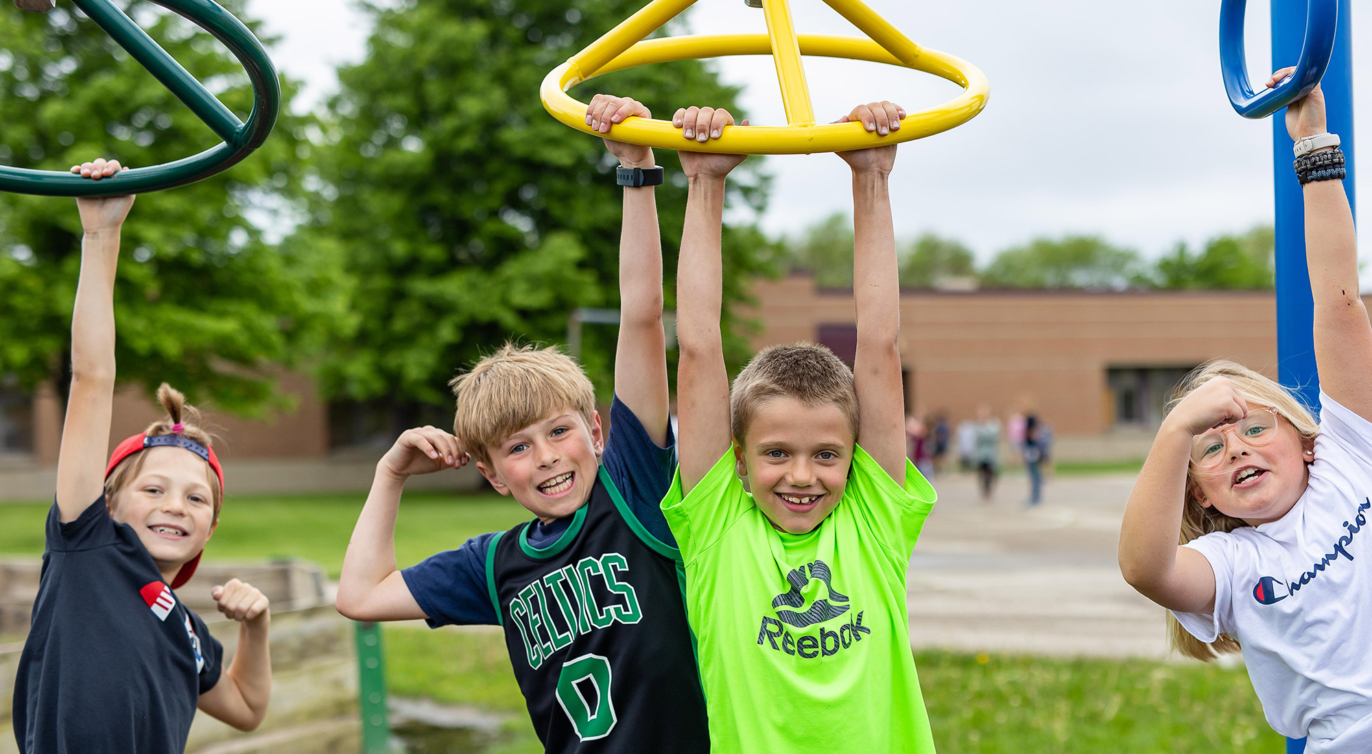 4 Pine Ridge students hanging on the playground, smiling at the camera