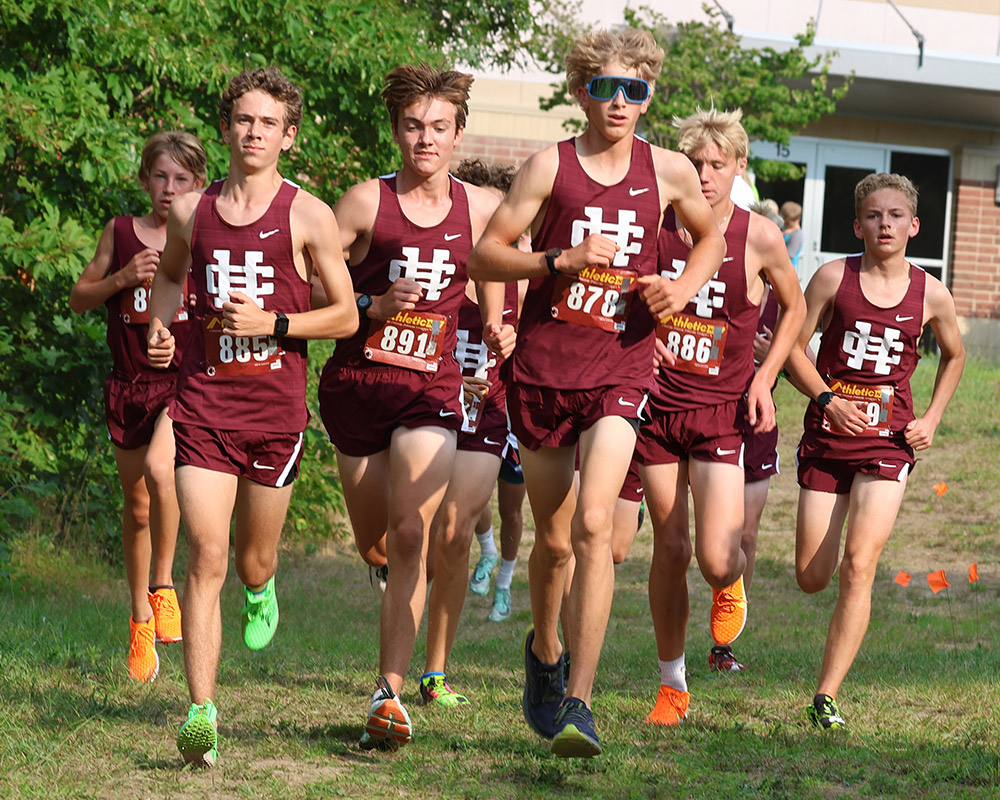 Boys cross country team running toward the camera, all in maroon