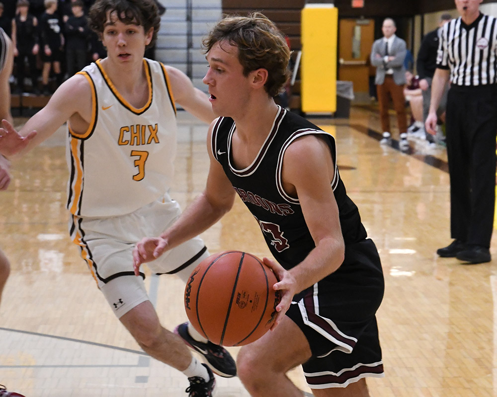 Varsity basketball player dribbling ball vs. Zeeland Chix