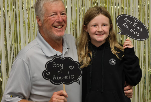 Opa und Enkelin halten Abuelo-Schilder und lächeln in die Kamera