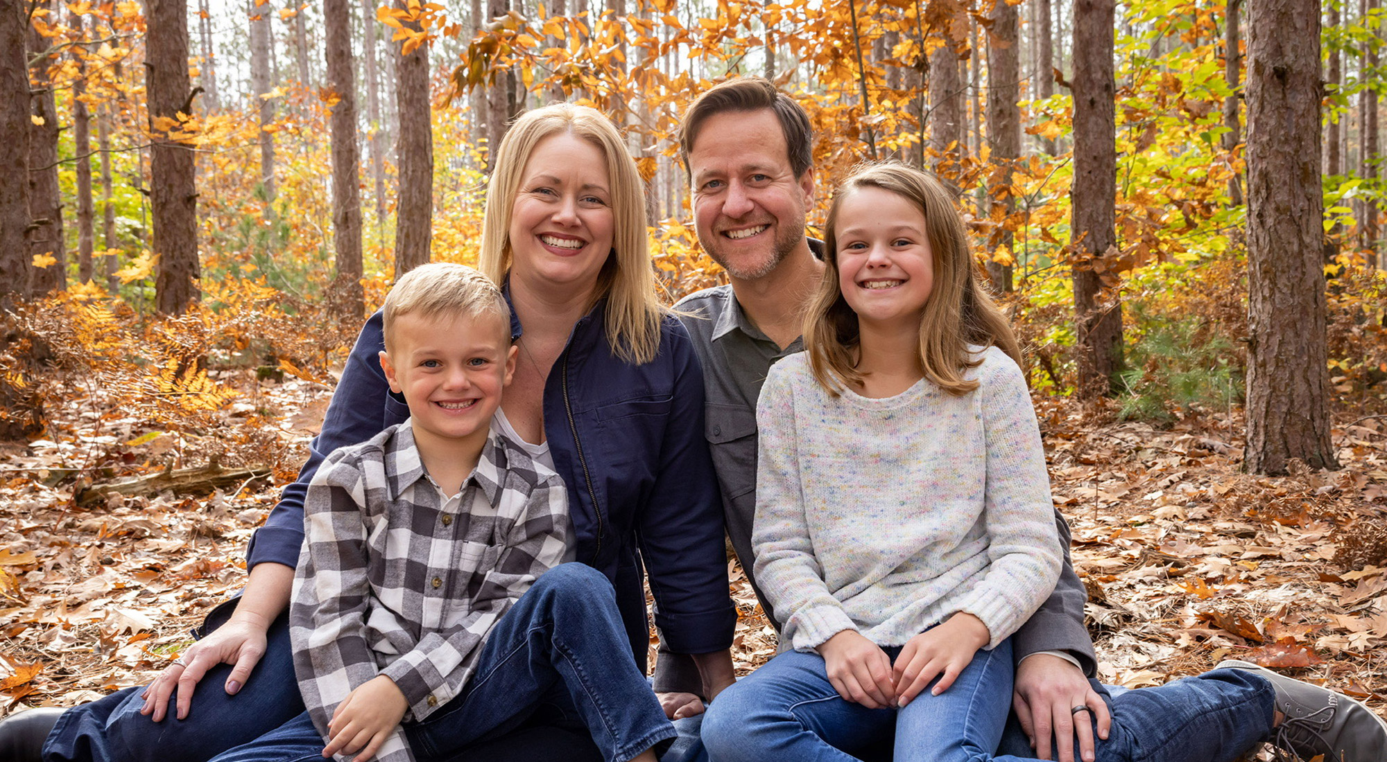 Wernlund family sitting in the woods and smiling at the camera
