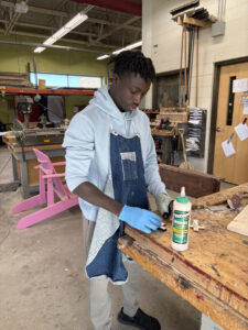 High school boy gluing a project in the woodshop
