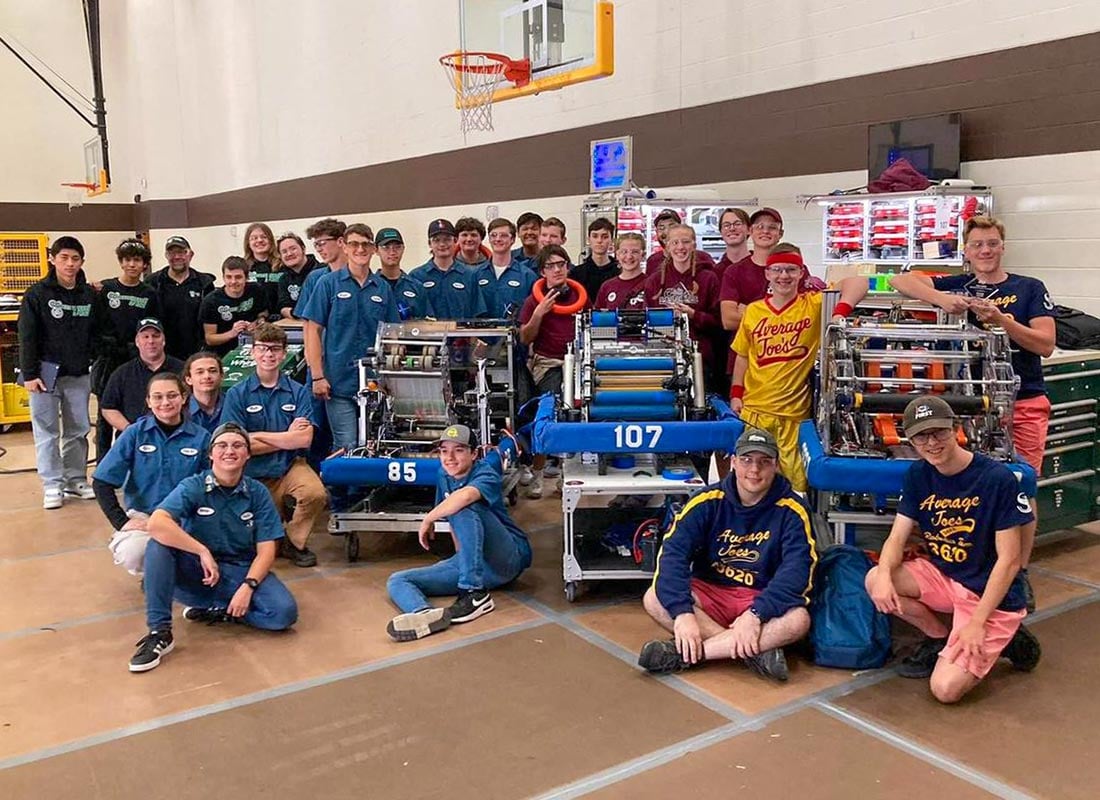 HC Team 107 posing for a photo with their robot and two other teams