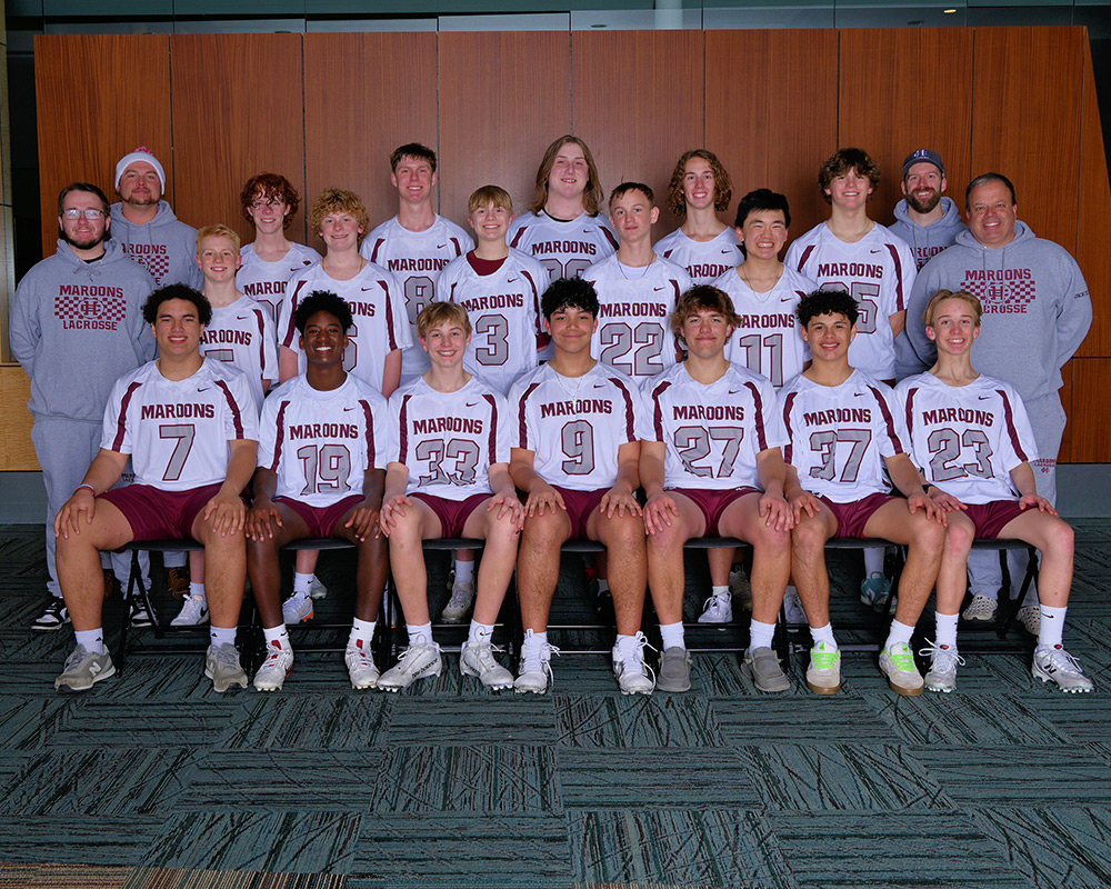 Boys JV lacrosse team lined up and smiling at the camera.