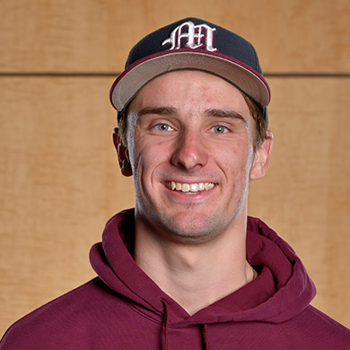 JV baseball coach smiling at the camera.