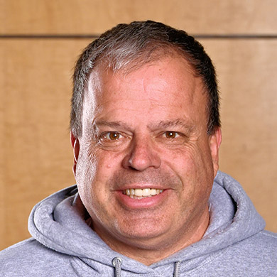 Varsity boys lacrosse coach smiling at the camera