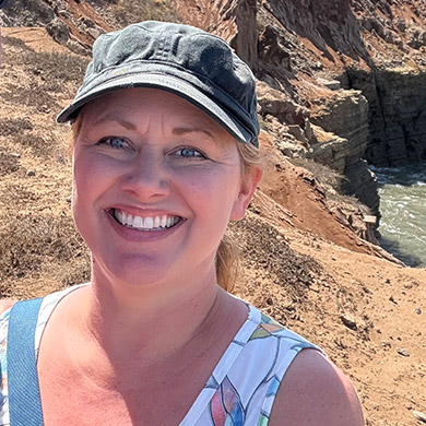Evonne Wernlund wearing a baseball hat outside and smiling at the camera