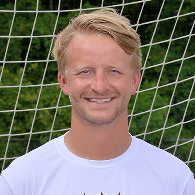 Coach Johns smiling at the camera.