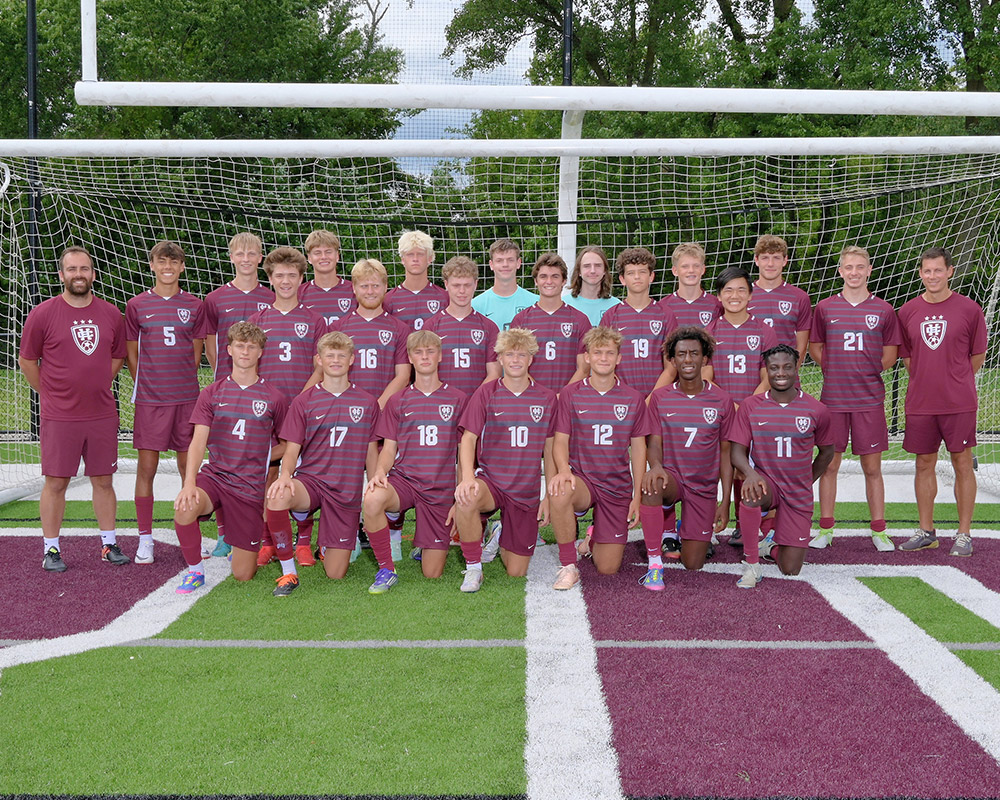 Boys varsity soccer team smiling at the camera.