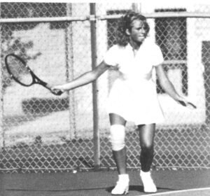 Aimee Armstrong playing tennis as a high school student in black and white