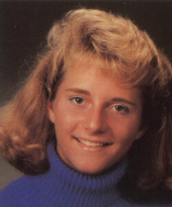 Aimee Armstrong smiling at the camera in her senior photo from 1989