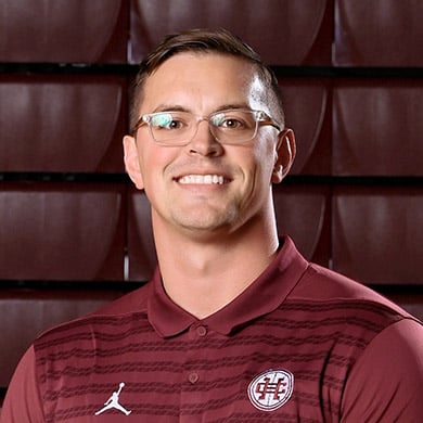 Boys JV basketball coach Snikkers smiling at the camera.