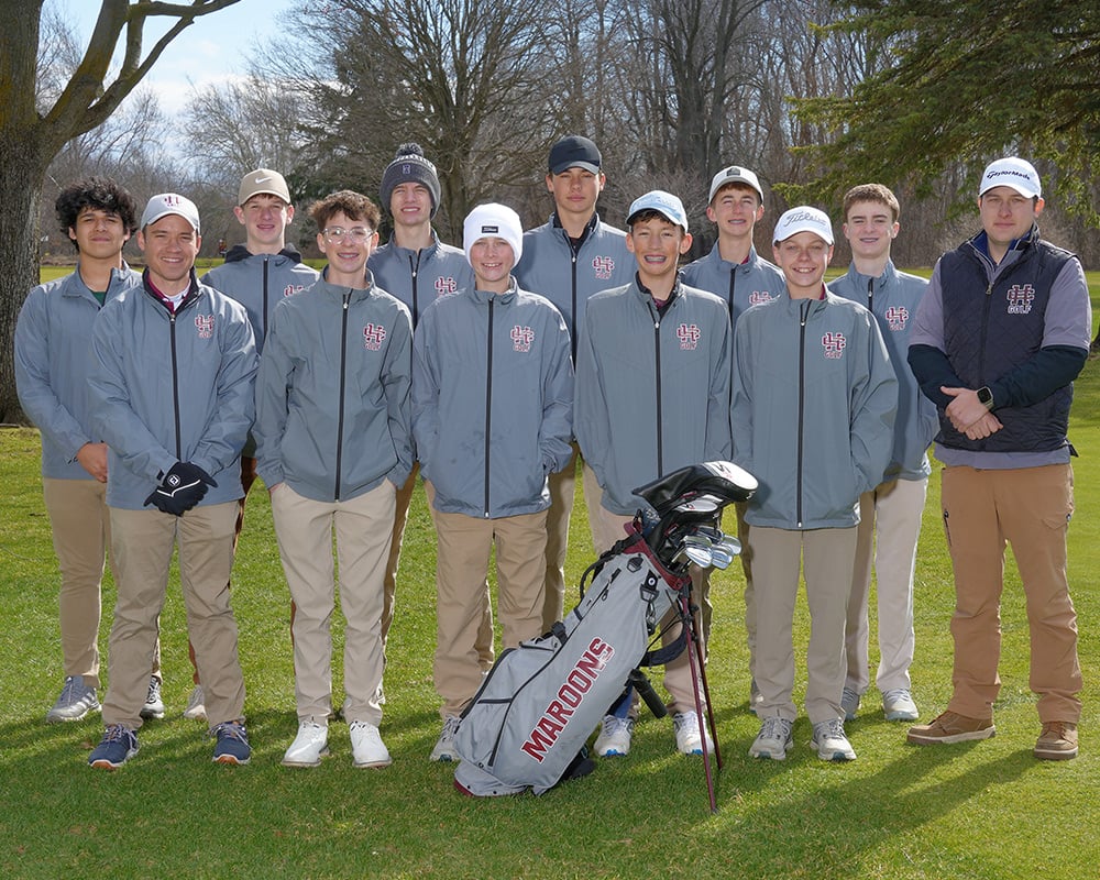 Boys JV golf team looking at the camera, standing outside