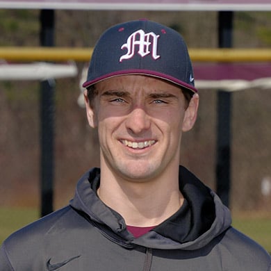 JV baseball coach smiling at the camera.