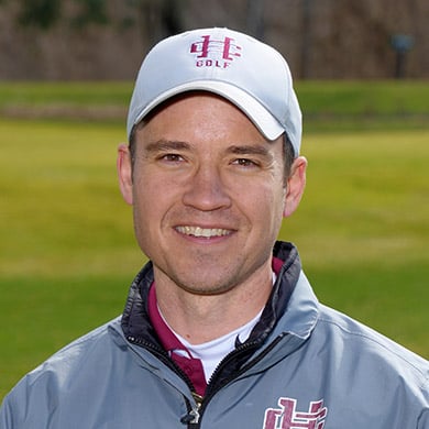 Boys JV golf coach smiling at the camera, outdoors