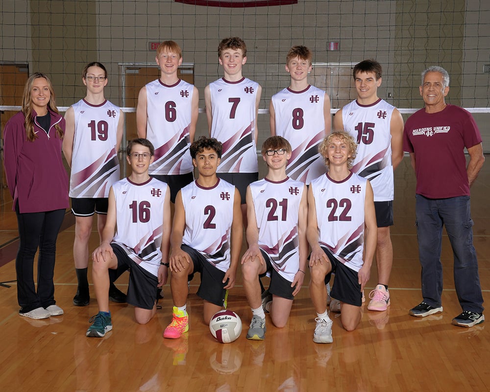 Boys JV volleyball team smiling at the camera.