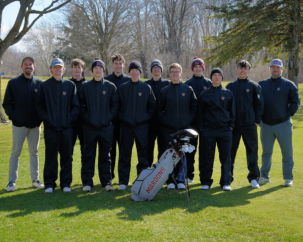 Varsity boys golf team smiling at the camera, outdoors