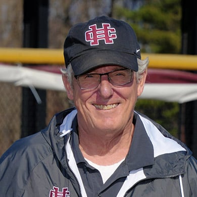 JV softball coach smiling at the camera.