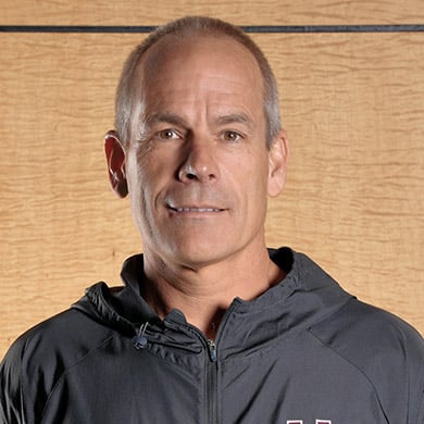 Track coach smiling at the camera.